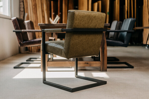 Chaise à accoudoirs cantilever élégante avec revêtement en cuir et structure en acier noir