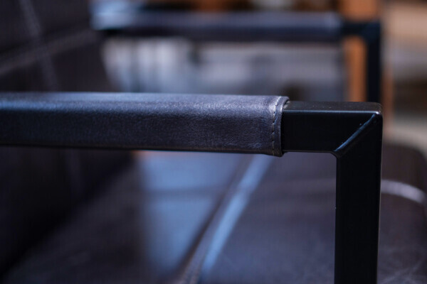 détail de la chaise avec accoudoir en acier recouvert de cuir
