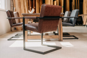 Chaise en cuir de qualité supérieure de type Freischwinger avec accoudoirs et cadre en acier noir pour des espaces repas contemporains