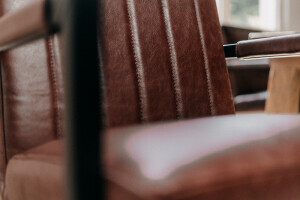 Gros plan sur l'assise en cuir marron de haute qualité d'une chaise de salle à manger design avec structure cantilever