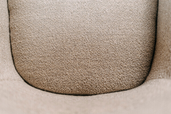 Gros plan sur l'assise en tissu texturé d'une chaise de salle à manger moderne pivotante avec un revêtement de haute qualité
