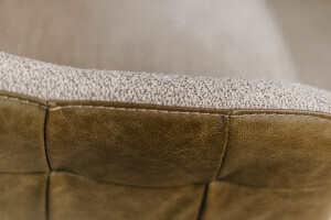 Vue détaillée du passage du cuir au tissu sur le haut dossier de la chaise de salle à manger pivotante Gordon